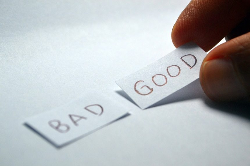 Image, Hand laying down slips of paper with the words 'Bad' and 'Good' written on them.