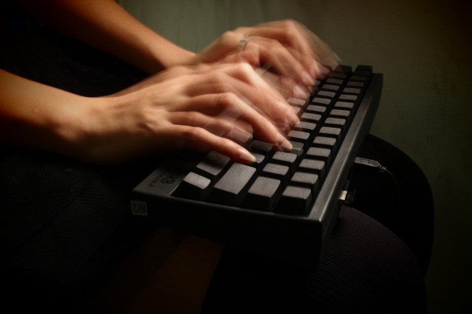 Image, fingers typing quickly on a keyboard.
