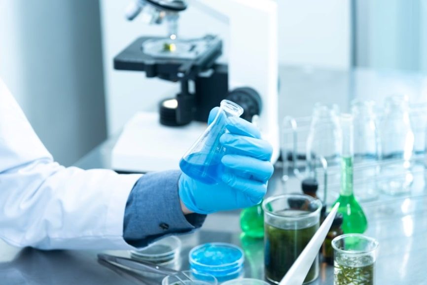 A person holding a laboratory flask.