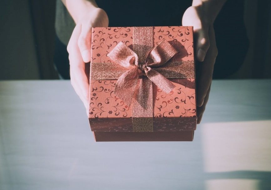 Two hands offering a gift to someone.