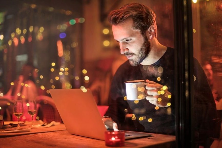 Image, Man in restaurant with laptop.