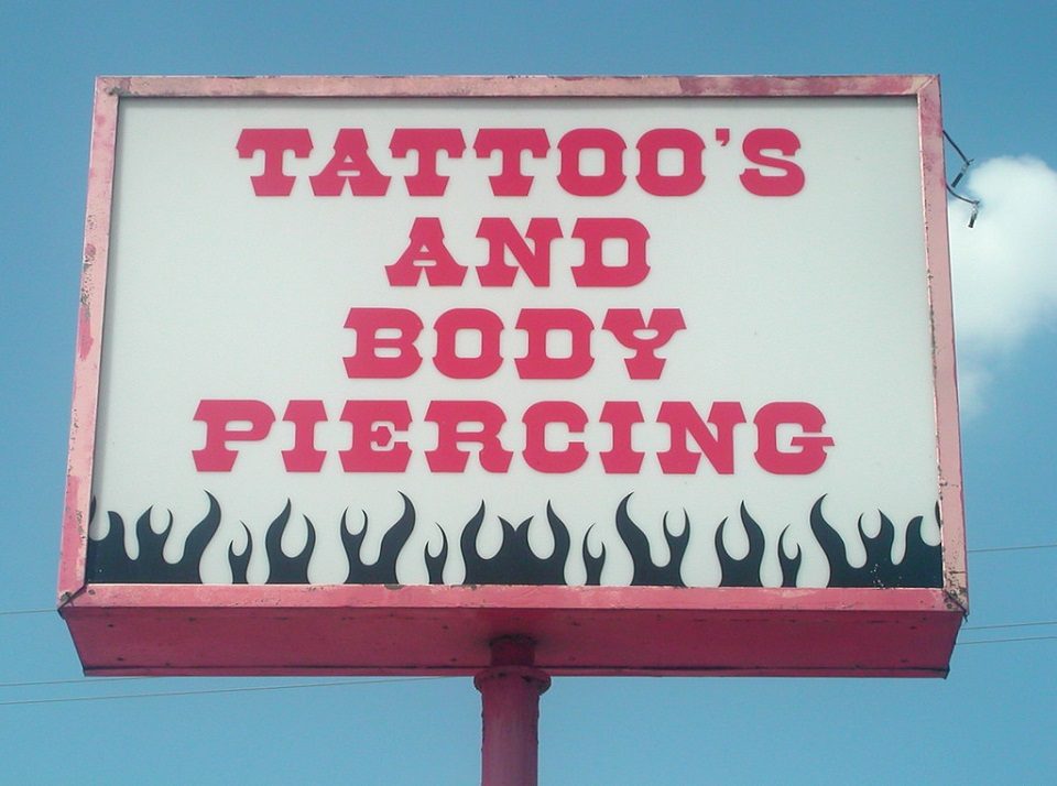 Image, Sign for a tattoo and body piercing shop with a misplaced apostrophe.