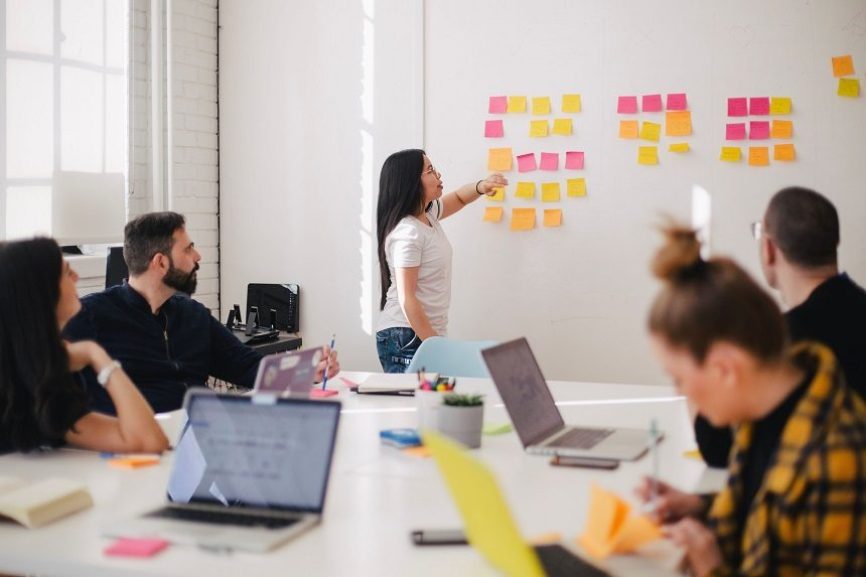 Image, Group of people at a workshop, with whiteboard and sticky notes.
