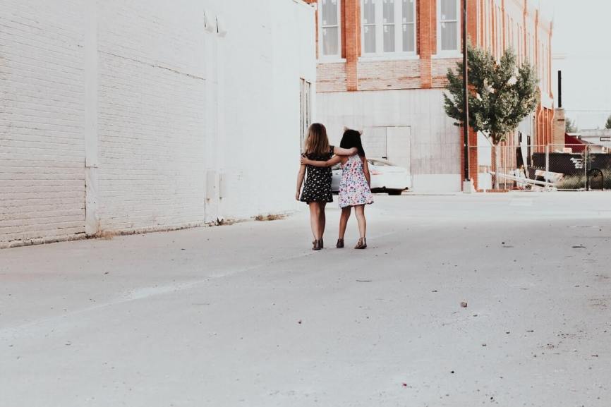 Image, two little girls walking down an alleyway with their arms around each other