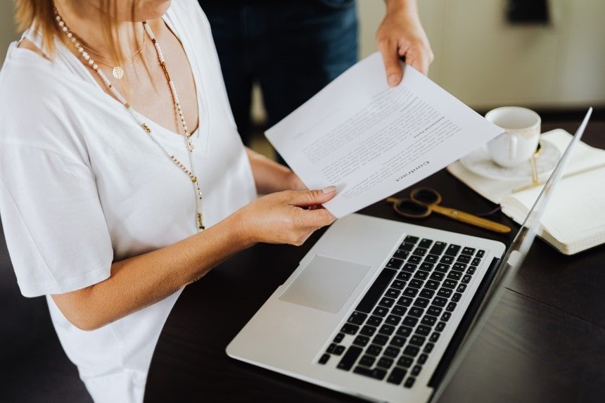 A man hands a contract to a woman. The contract is in plain language if she can read it once, understand it, and act on the information.