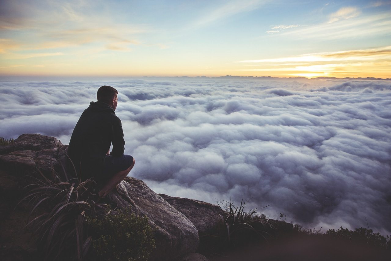 Image, Man looking across the tops of clouds.