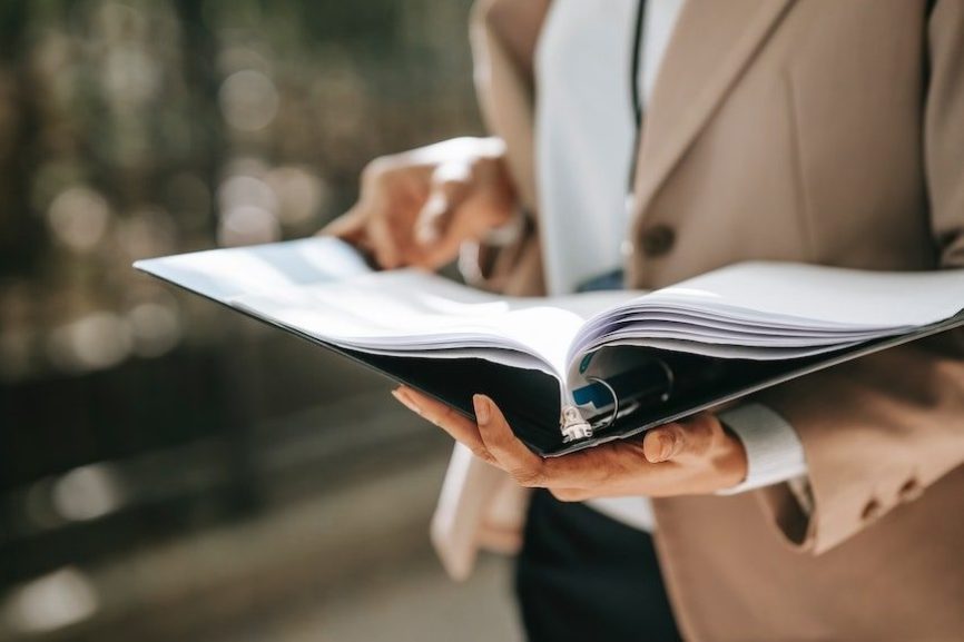 Close-up of a file binder in a woman’s hands.