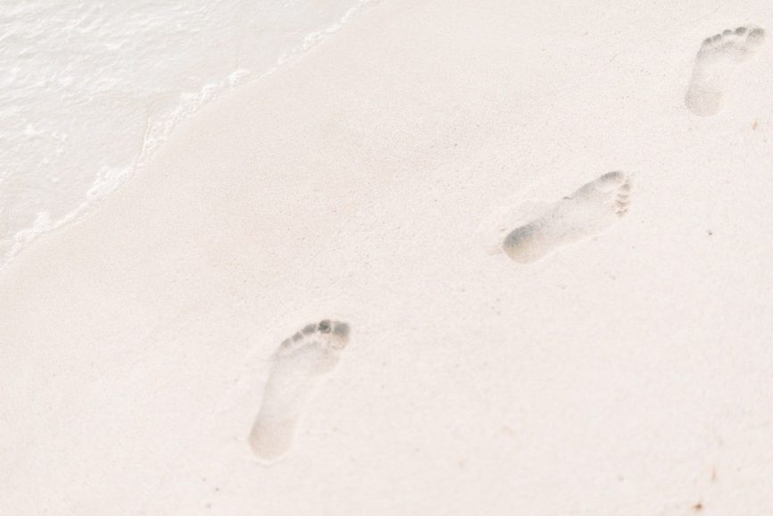 Image, human footprints on a sandy beach by the waterline