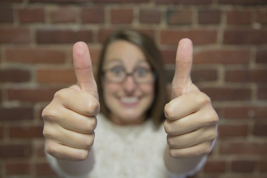 Image, woman wearing glasses giving the thumbs up sign