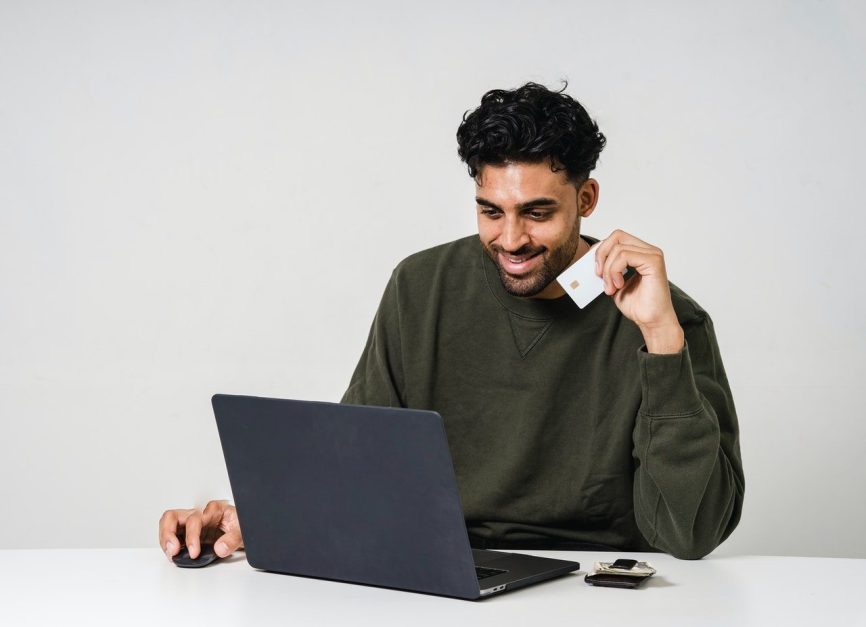 Man sitting in front of laptop looking pleased with what he is seeing onscreen