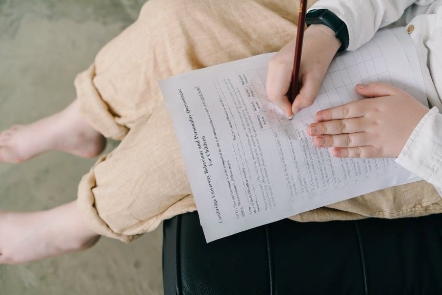 Child filling in questionnaire with a pencil