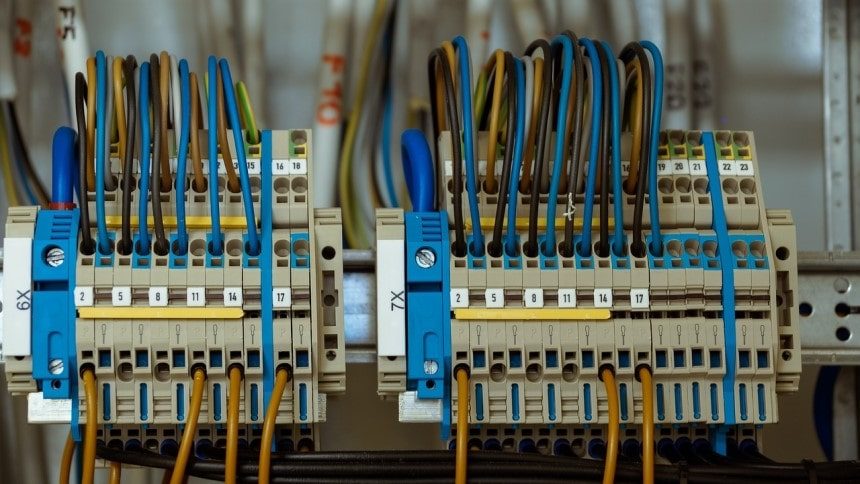 Close-up of an electrical device with dozens of blue, brown, and black wires plugged into numbered ports.
