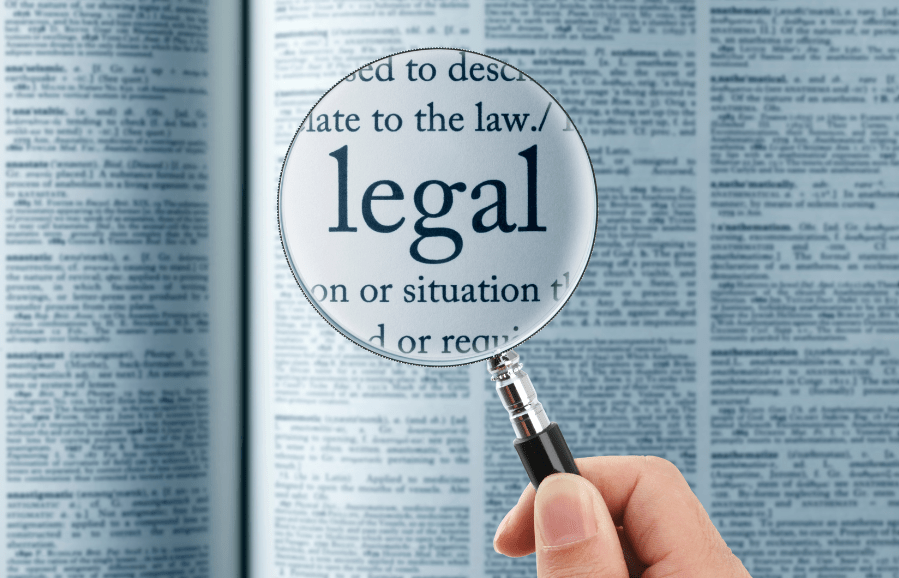 Magnifying glass over dense text, highlighting the word ‘legal’