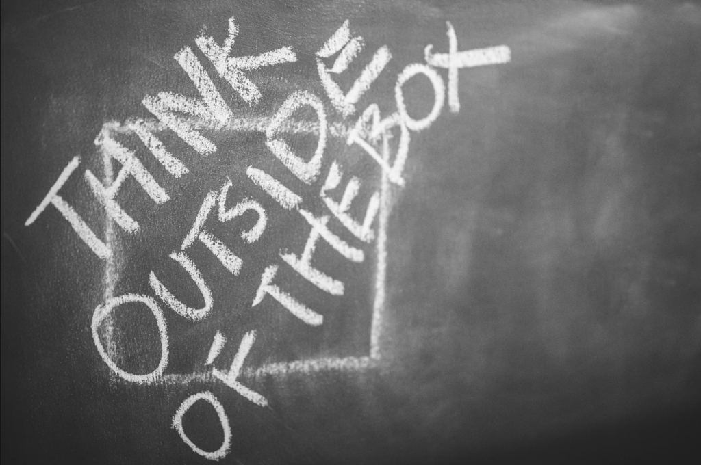 Image, writing on blackboard saying 'thing outside the box'.